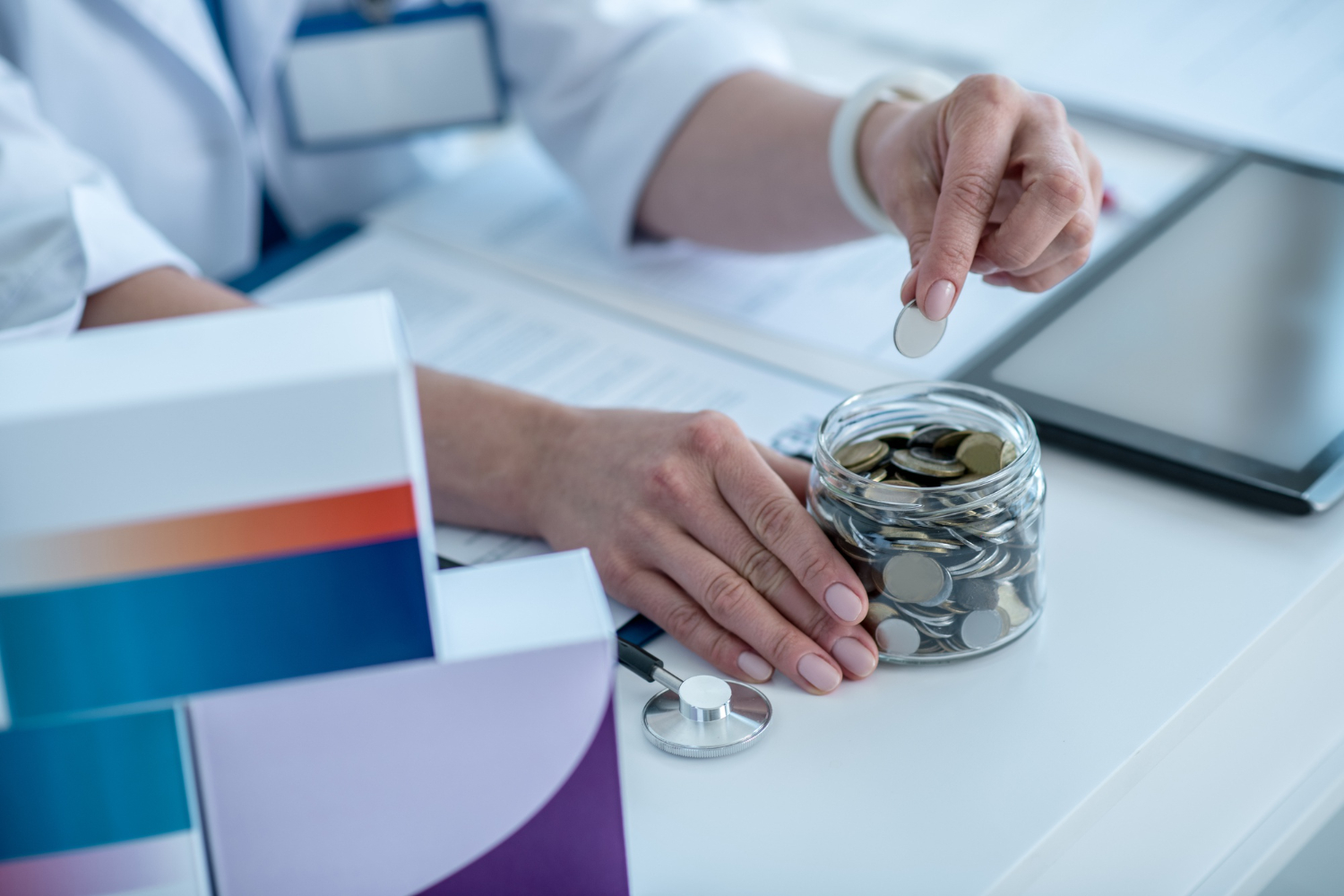 zblizenie kobiecej dloni wkladanie monet do sloika